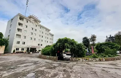 نمای ساختمان سفید و حیاط هتل ابریشمی لاهیجان