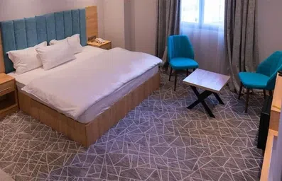 اتاق با مبلمان چوبی و دکور فیروزه ای در هتل مناهل رویال ملکی نجف