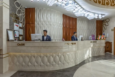 پذیرش هتل الماس نوین مشهد شامل کانتری سنگی با رنگ‌های سفید و قهوه‌ای