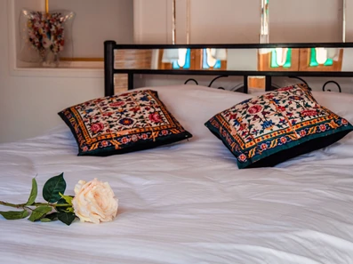 تخت با کوسن های سوزندوزی در اقامتگاه سنتی بابا باشی شیراز