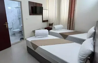 اتاق با دو تخت سینگل و توالت فرنگی در هتل بیستون طلایی مشهد