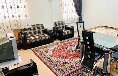 آپارتمان مبله با فرش، تلویزیون و میز نهارخوری در هتل گل نرگس بندرانزلی