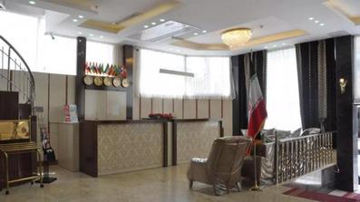 مبل راحتی قهوه ای رنگ رو به روی پذیرش لابی هتل هرمس مشهد. کف سالن با سنگ رنگ روشن پوشیده شده