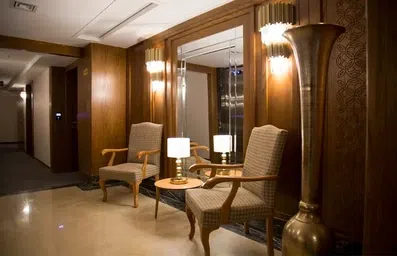 آینه به همراه میز و صندلی در راهروهای هتل جوارالملک مشهد