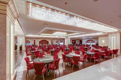 نمایی از رستوران هتل خورشید هشتم مشهد با مبلمان قرمز رنگ و کف و دیواره هایی با سنگ زینتی درخشان