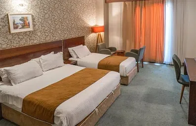 اتاق با یک تخت دو نفره و یک تخت سینگل در هتل لیلیوم کیش