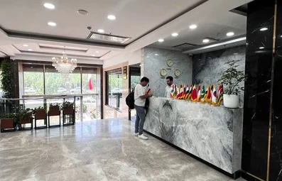 پذیرش هتل مهسان قم با نمایی از سنگ مرمر خاکستری و پرچم کشورها