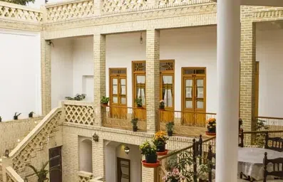 پنجره های چوبی و بلند واحدهای اقامتگاه معمار کاشان به سمت حیاط