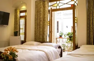 اتاق دو تخته با پنجره‌های بلند و فضای مینیمال سنتی