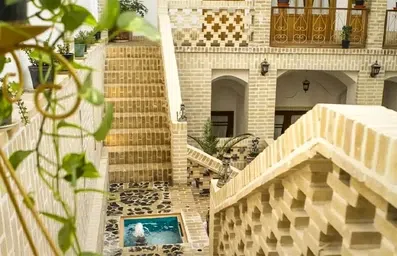 راه پله های متقارن حیاط اقامتگاه سنتی معمار کاشان به سمت طبقات بالا