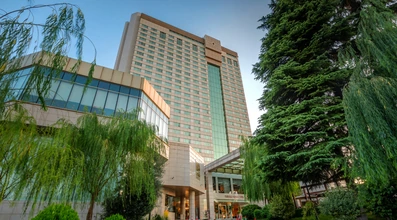 نمای هتل پارسیان آزادی تهران از میان درختان