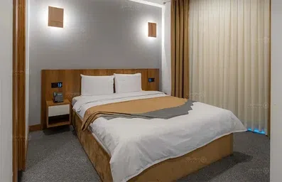 اتاق دو تخته شیک با دکور چوب تیره و نورپردازی های زیبا در هتل رادیس مشهد