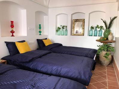 سه تخت خواب با ملحفه سورمه ای و بالشت زرد