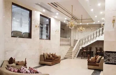 لابی هتل سلما مشهد با سنگ فرش های سفید و مبلمان سلطنتی قرمز