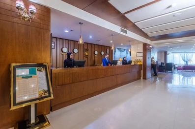 قسمت پذیرش هتل سی نور مشهد با نمای چوب‌کاری قهوه‌ای در سالن بزرگ لابی