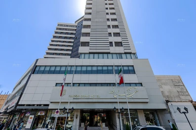 نمای ساختمان 22 طبقه هتل بزرگ سی نور مشهد با سنگ سفید و پنجره‌های آبی