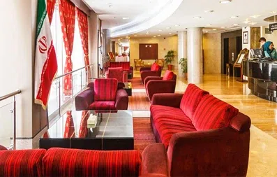 لابی هتل توس مشهد با مبلمان قرمز و پنجره های سراسری