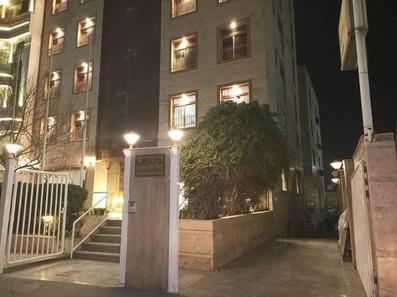 نمای هتل زاگرس در شب. ورودی سنگ کاری شده با درختچه های سبز در کنار پلکان.