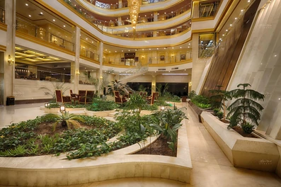 فضای سبز درون لابی هتل ضیافت الزهرا که با رنگ های طلایی تزیین و طراحی شده