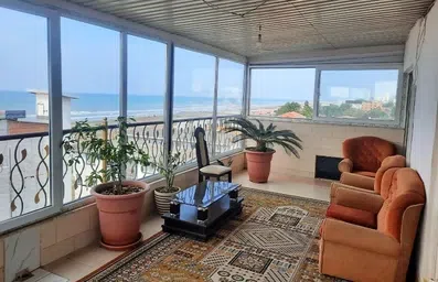 تراس مسقف مبله با پنجره های سراسری به سمت دریا در متل پوریا بابلسر