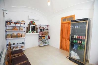 فروشگاه سنتی که در طبقات آن جعبه های چوبی قرار دارد. دیوار های این فضا سفید است و صندلی های چوبی سنتی در آن به چشم میخورد.